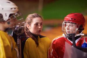 adolescente ghiaccio hockey Giocatori squadra incontro con allenatore foto