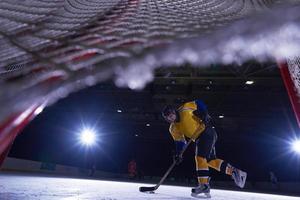 adolescente ghiaccio hockey giocatore nel azione foto