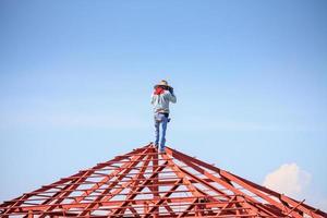 lavoratori del saldatore che installano la struttura del telaio in acciaio del tetto della casa in un cantiere edile foto