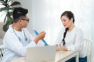 assistenza sanitaria concetto di ostetrico ginecologo medico consultare con giovane donna di sua Salute nel clinica o Ospedale. foto