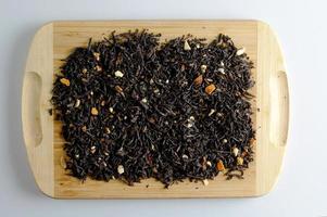 asciutto tè basato su nero con pezzi di agrume arancia e Limone su un' di legno sfondo. foto