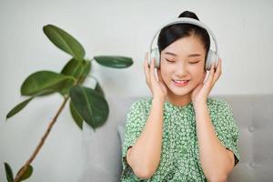 asiatico donna ascoltando per musica con cuffie a casa senza fili tecnologia con copia spazio. foto