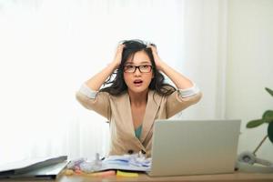 un' giovane donna d'affari è guardare stressato come lei lavori a sua computer. orizzontale sparo. foto