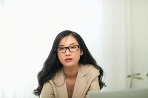 annoiato giovane donna sedersi a casa ufficio tavolo Guarda nel distanza incapace per opera a computer portatile, foto