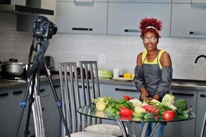 africano americano donna le riprese sua blog trasmissione di salutare cibo a casa cucina. lei tagli il cavolo. foto