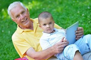 nonno e bambino nel parco utilizzando tavoletta foto