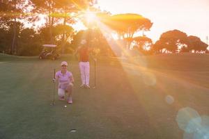 coppia su golf corso a tramonto foto