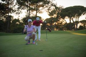 coppia su golf corso a tramonto foto