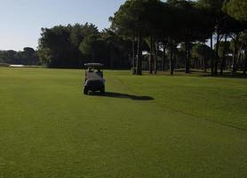 golf Giocatori guida carrello a corso foto