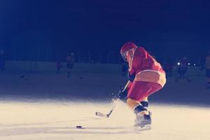 adolescente ghiaccio hockey giocatore nel azione foto