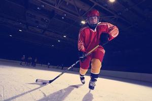 adolescente ghiaccio hockey giocatore nel azione foto