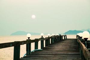 una passerella di legno che si protende nel mare. concetto di viaggio di vacanza foto