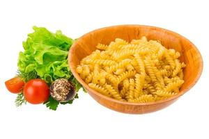 fusilli in una ciotola su sfondo bianco foto