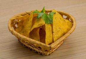 nachos in un cestino su fondo di legno foto