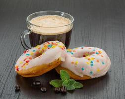 caffè con ciambelle su di legno sfondo foto