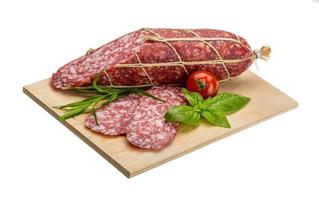 salame su di legno piatto e bianca sfondo foto