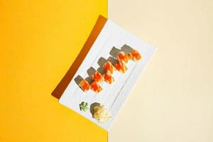 Sushi rotoli con anguilla, gamberetto, cetriolo e crema formaggio, decorato con rosso caviale. difficile luce, in profondità ombra foto