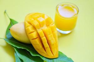 Mango estate succo nel bicchiere con dolce maturo fetta di Mango su verde le foglie a partire dal albero tropicale frutta foto