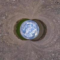 inversione del piccolo pianeta blu trasformazione del panorama sferico a 360 gradi. vista aerea astratta sferica su strada con bellissime nuvole fantastiche. curvatura dello spazio. foto