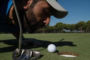 golf giocatore soffiaggio palla nel buco foto