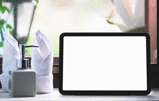 tablet per lavorare su una scrivania in legno, uno schermo tablet vuoto può aggiungere testo o altri media. foto