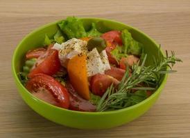 greco insalata nel un' ciotola su di legno sfondo foto