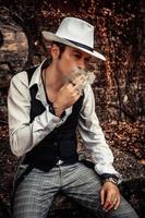 fedora styled uomo fumo un' sigaretta. foto
