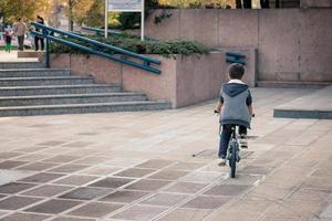 piccolo ragazzo equitazione bicicletta nel il città. foto