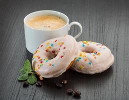 caffè con ciambelle su di legno sfondo foto