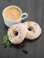 caffè con ciambelle su di legno sfondo foto