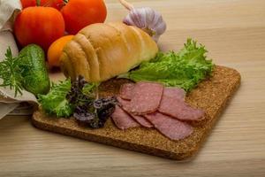 salsicce di salame sul piatto di legno foto