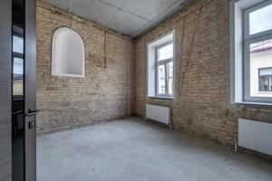 vuoto soffitta camera con mattone parete e riparazione e senza mobilia per ufficio foto