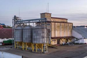 moderno granaio ascensore con argento silos su agro-trasformazione e produzione pianta per in lavorazione essiccazione pulizia e Conservazione di agricolo prodotti, Farina, cereali e grano. foto