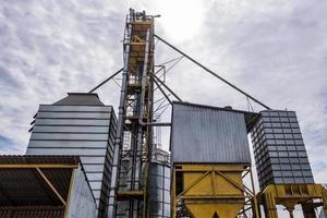 moderno ascensore per granaio. silos d'argento su impianti di agro-lavorazione e produzione per la lavorazione di essiccamento, pulitura e stoccaggio di prodotti agricoli, farine, cereali e granaglie. foto