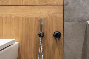 wc e dettaglio di un bidet doccia ad angolo con attacco doccia a parete foto