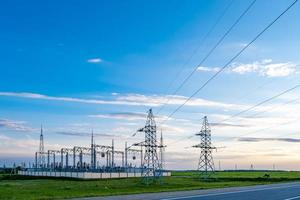 silhouette delle torri del pilone elettrico ad alta tensione sullo sfondo di belle nuvole serali foto