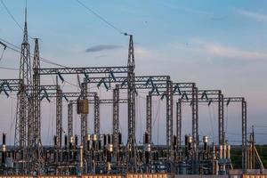 silhouette delle torri del pilone elettrico ad alta tensione sullo sfondo di belle nuvole serali foto