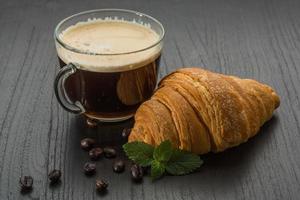 caffè con brioche su di legno sfondo foto