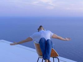 rilassato giovane uomo a casa su balcone foto