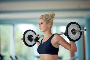 giovane donna nel fitness Palestra sollevamento pesi foto