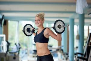 giovane donna nel fitness Palestra sollevamento pesi foto