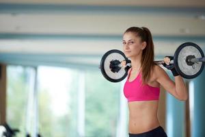 giovane donna nel fitness Palestra sollevamento pesi foto