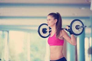 giovane donna nel fitness Palestra sollevamento pesi foto