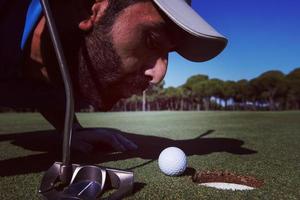 golf giocatore soffiaggio palla nel buco foto