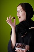 donna nel abaya Tenere un' Data frutta e bicchiere di acqua foto