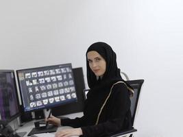 musulmano femmina grafico progettista Lavorando su computer utilizzando grafico tavoletta e Due monitor foto