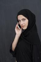 giovane musulmano donna d'affari nel tradizionale Abiti o abaya parlando su il smartphone foto