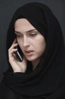 giovane musulmano donna d'affari nel tradizionale Abiti o abaya parlando su il smartphone foto