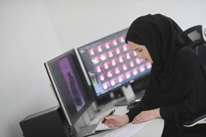musulmano femmina grafico progettista Lavorando su computer foto