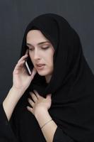 giovane musulmano donna d'affari nel tradizionale Abiti o abaya parlando su il smartphone foto